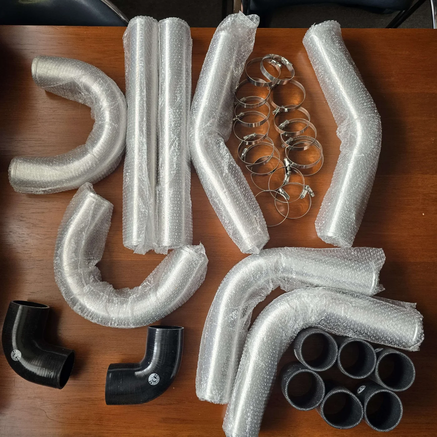 Wrapped piping kit with silicone couplers and hose clamps